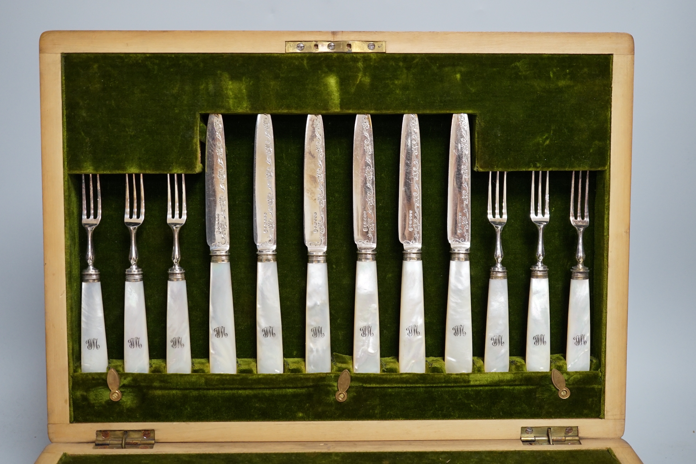 A mahogany case of plated cutlery and part set of mother of pearl handled dessert knives and forks, largest 46cm wide